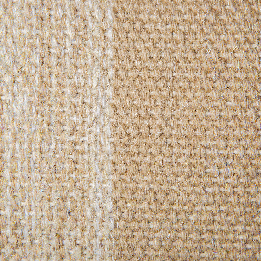 detail of large hand woven wool lumbar pillow in camel and cream with a white and green piping