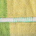 detail of hand woven wolen lumbar pillow in two tones green with white and contrasting green piping