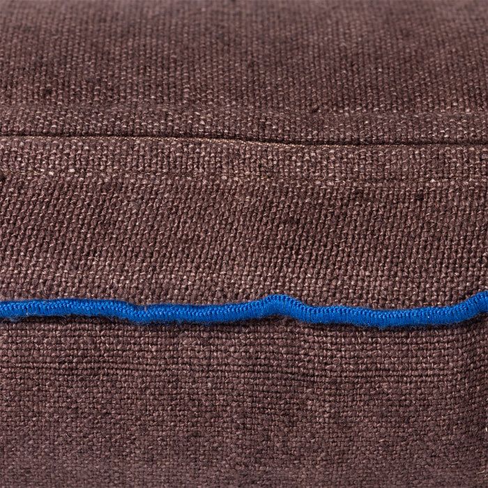 detail of brown linen lumbar pillow with blue cotton trim