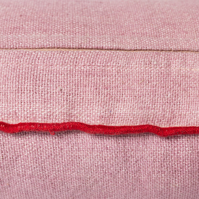 detail of pink linen lumbar pillow with red cotton trim
