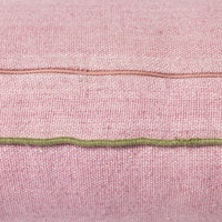 detail of pink linen lumbar shaped pillow with green cotton trim