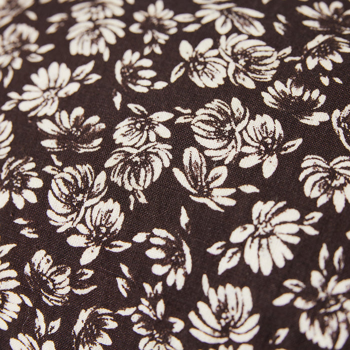 close up fabric brown vintage style lumbar pillow with white flowers