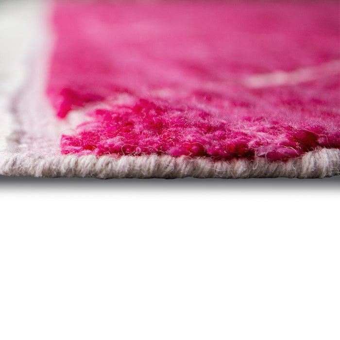 detail of long side of pink hand knotted woolen rug
