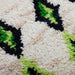 detail of long runner made from hand knotted natural wool with neon green and black pattern