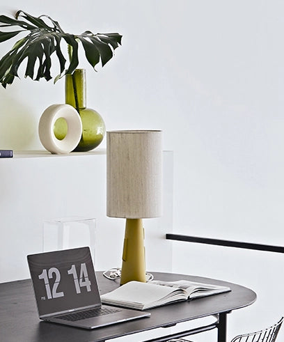 funky mustard yellow base with a natural linen shade on a black table next to a large digital clock