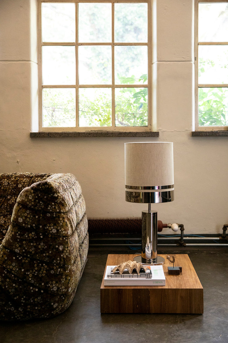 brown sofa, low teak wood side table plateau with chrome and linen table lamp 