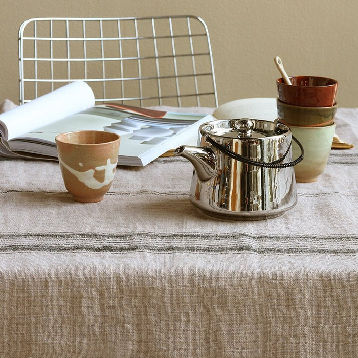 grey and charcoal striped linen table cloth with silver tea pot and ceramic mugs