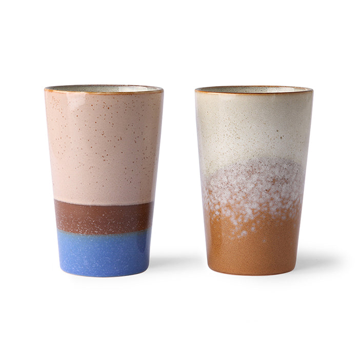 two slim, tall ceramic mugs in blue and brown colors
