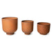 3 metal planters in a row in a ginger terracotta color