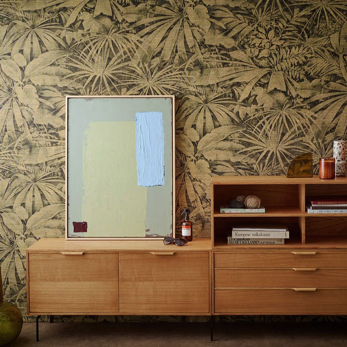 Danish style cabinet with drawers and an abstract painting in calming colors against a flower wallpaper