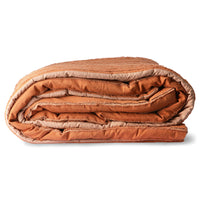 Folded striped duvet cover in orange, beige, and brown colors on a white background