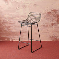 marble look pink wall with black metal stool