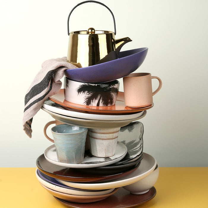 stack of colorful ceramics including a natural linen striped napkin