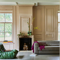 contemporary style club couch in a taupe color fabric that is a mix of linen and cotton in a room next to a fire place