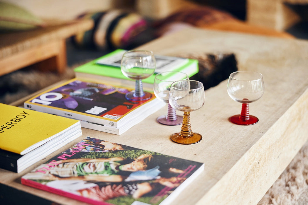 coffee table with books and a blue, purple, orange and red retro style wine glasses
