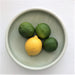 deep green plate with lemon and three limes
