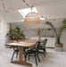 ding room with a large natural wicker basket light and black chairs