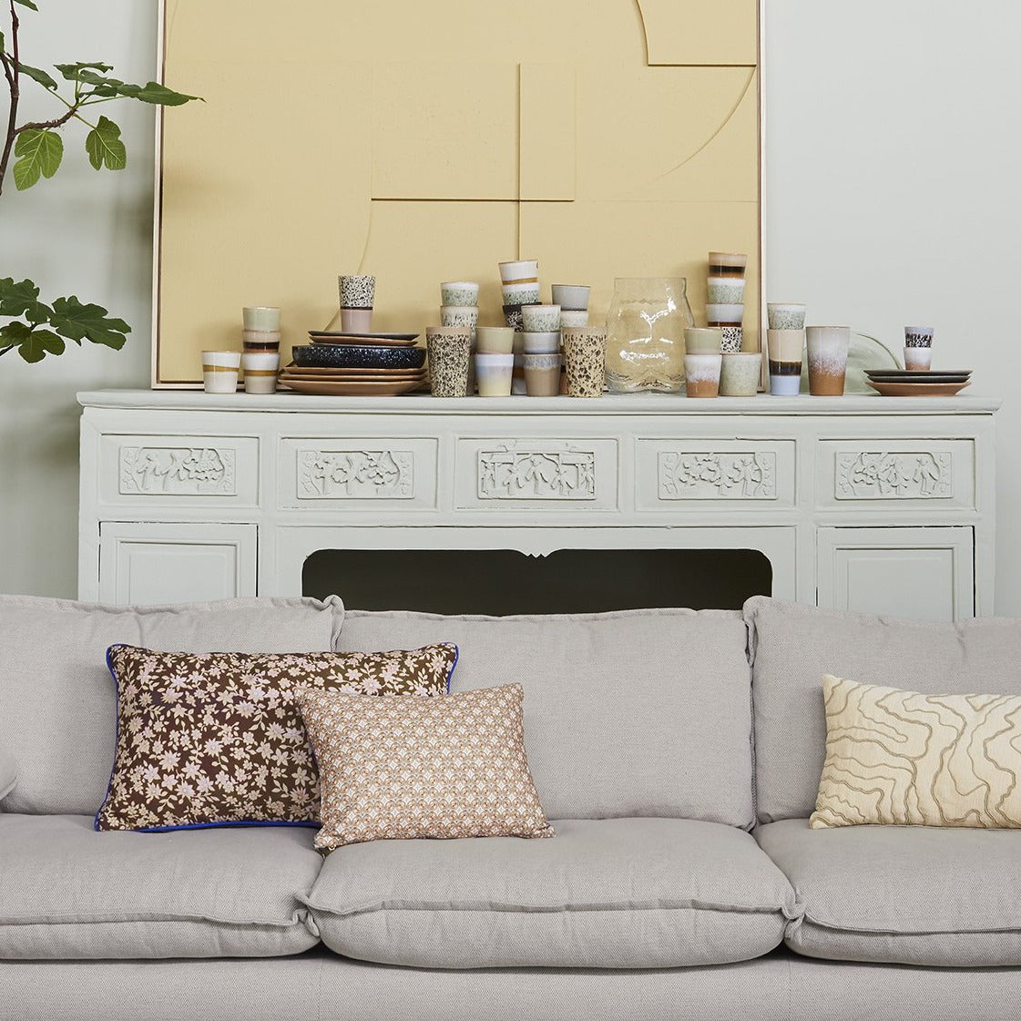 grey sofa with brown vintage inspired pillow with brown pattern and blue trim