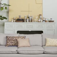 grey sofa with brown vintage inspired pillow with brown pattern and blue trim