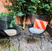 black egg chairs in a patio with velvet pillows in blue and red