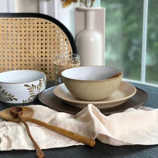 table near window with brown leaf porcelain bowl and wooden spoons
