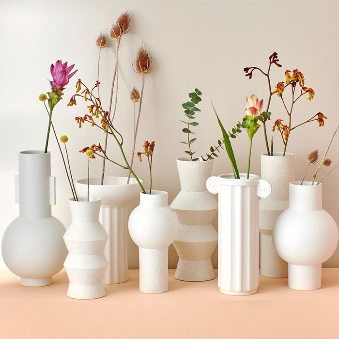 white speckled vases on peach colored table