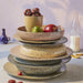 taupe colored ceramic deep plate on a stack with other earth tone colored ceramic plates