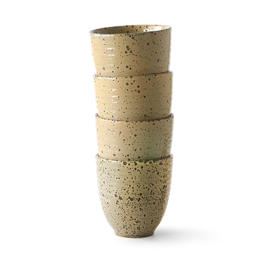 stack of 4 stoneware mugs with speckled glaze in a peachy color