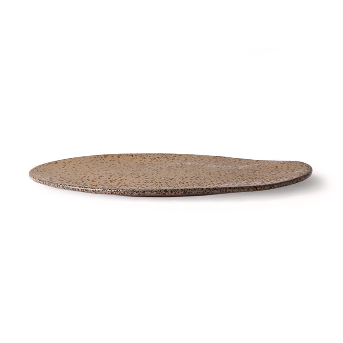 side view of an organic shaped, taupe colored stoneware side plate