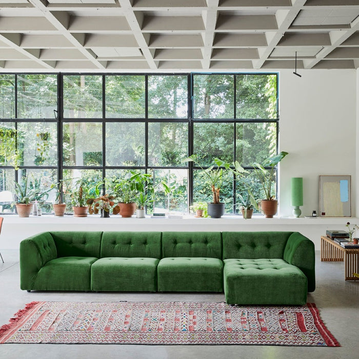 Mid Century Modern style living room with large window, green sofa and abstract painting in pistachio and blue