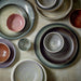 flat and deep porcelain plates in soft pastel and black and brown