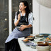 woman cooking in kitchen surrounded by hk-living ceramics