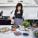 woman with apron preparing meal in kitchen