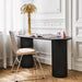black desk with brass palm tree lamp and metal chair with felt seat cushion