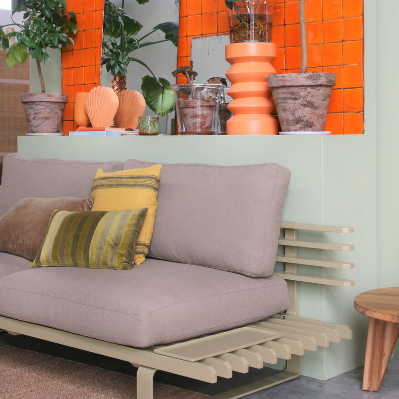outdoor / indoor sofa in an olive color with glass planter with stoneware inside planter