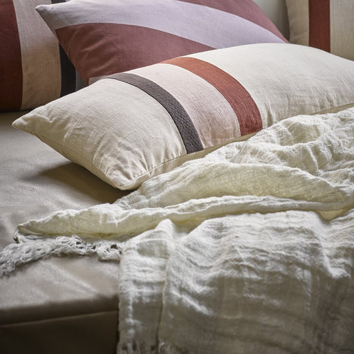 white linen coverlet with striped pillows