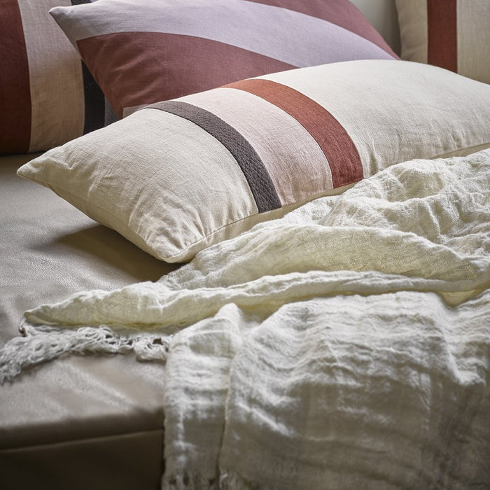 white linen coverlet with striped pillows
