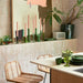 kitchen with taupe colored tiles, large abstract painting in peach and brown and green colored glassware
