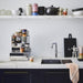 kitchen with marble counter top and marble shelving with 70's ceramics by design brand HKliving