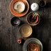 bowls in earth tones on a dark wooden table