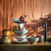 walnut brown wood with stack of Kyoto inspired porcelain dinnerware in earth tones 