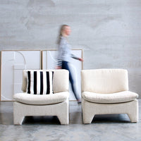 retro style lounche chairs in white cream color with paintings on wall