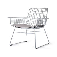 mid century modern style armrest chair in chrome with seat cushion in a light color