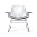 mid century modern style armrest chair in chrome with seat cushion in a light color