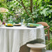 round table with linen table cloth and green tableware