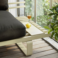 detail of olive green tray on an aluminium outdoor sofa with black seating cushion