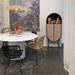 loft with dark cement floor, white dining table with chairs and black oval retro style cabinet