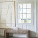 large white abstract art work on shiplap wall with upholstered bench