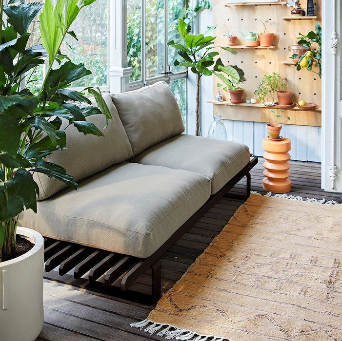 patio with aluminum sofa in charcoal and a neutral rug with graphics  