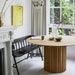 dining room with black shaker bench and round teak wooden table with pillar shaped base